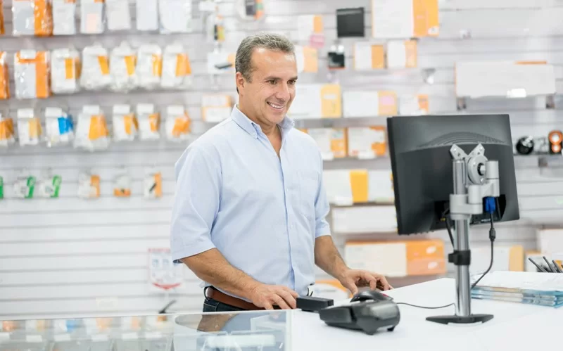 Casual man running an electronics store and working behind the counter