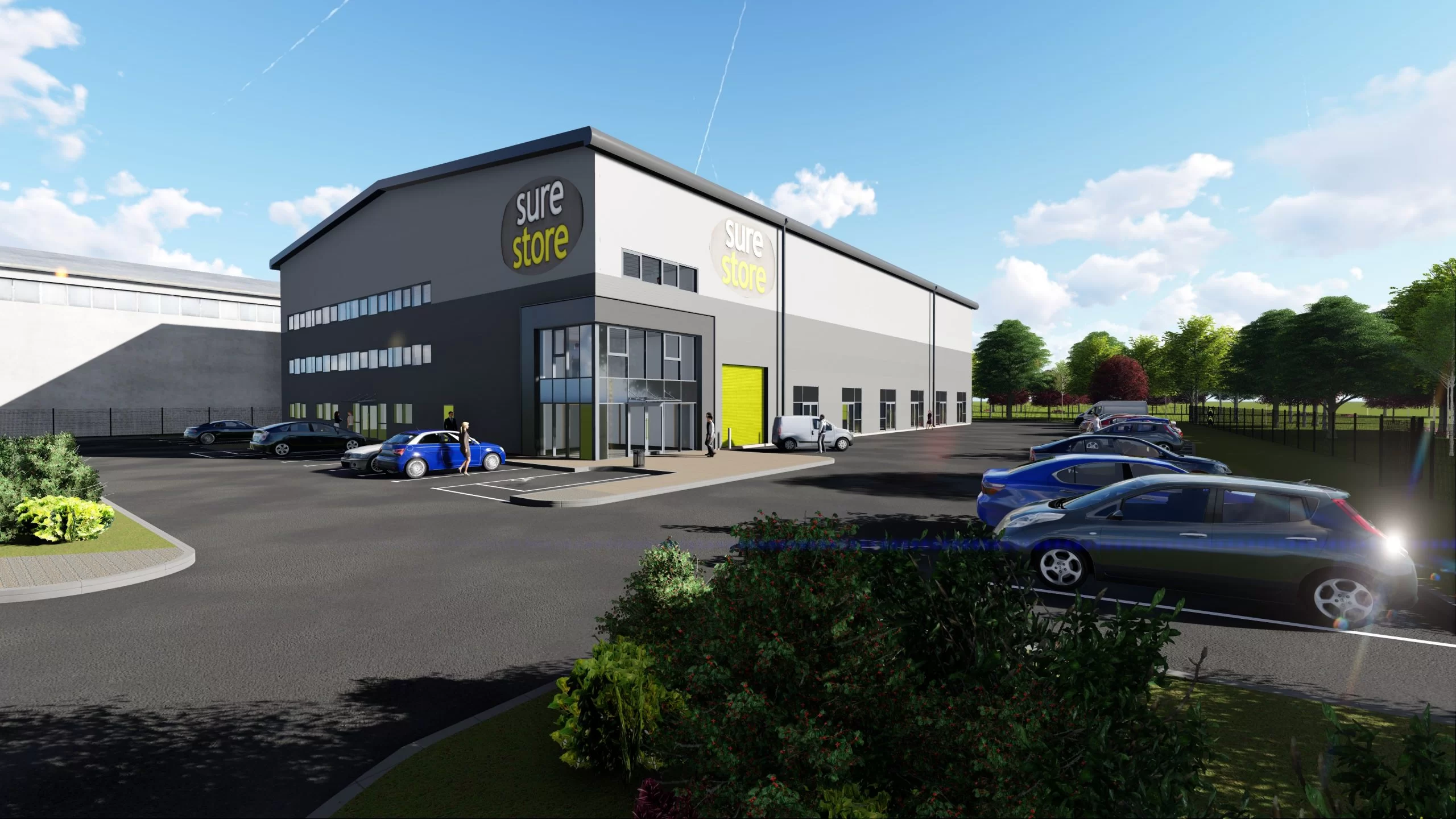 A modern warehouse building with a large glass entrance, labeled 'sure store,' situated in an open area. Several parked cars are visible in the foreground and greenery surrounds the parking lot under a clear blue sky.